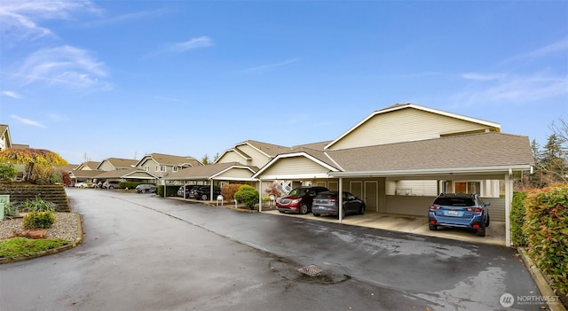 exterior space with covered parking and roof with shingles