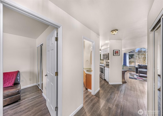 hallway featuring dark wood-style floors and baseboards