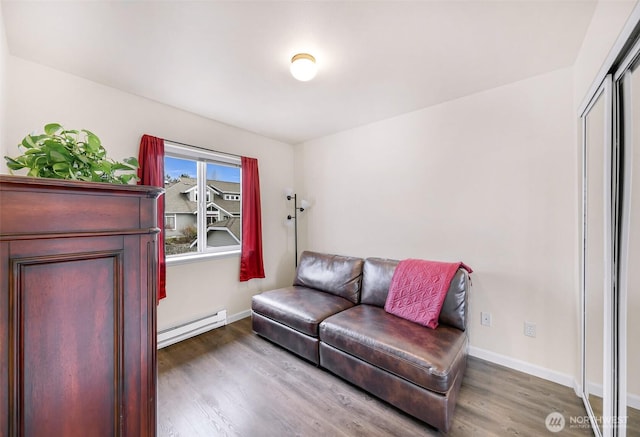 living room with baseboards, baseboard heating, and wood finished floors