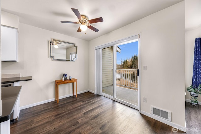 dining area with ceiling fan, dark wood-style flooring, visible vents, and baseboards