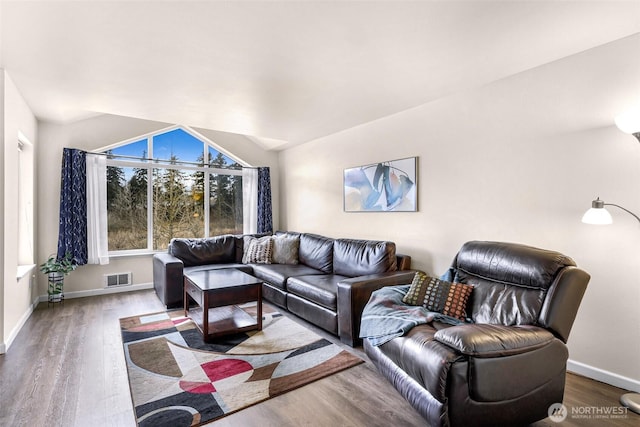 living room featuring visible vents, baseboards, and wood finished floors