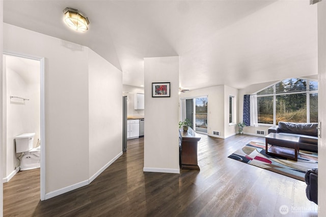 living area with wood finished floors, visible vents, and baseboards