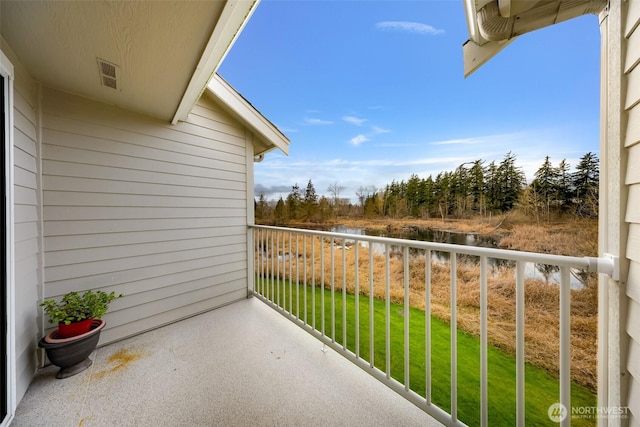 balcony featuring a water view and visible vents