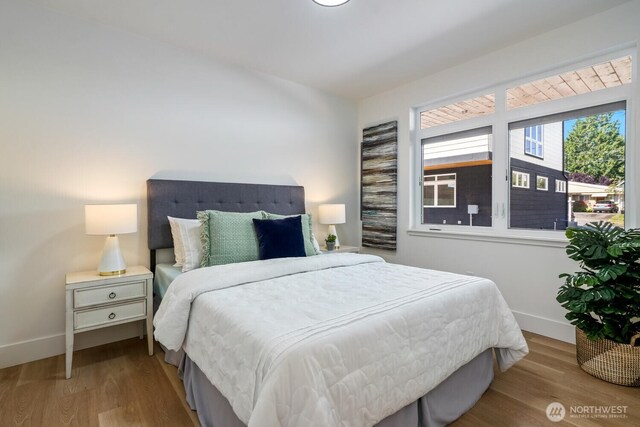 bedroom featuring baseboards and wood finished floors