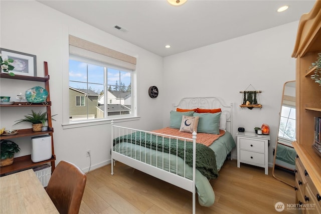 bedroom with multiple windows, wood finished floors, visible vents, and recessed lighting