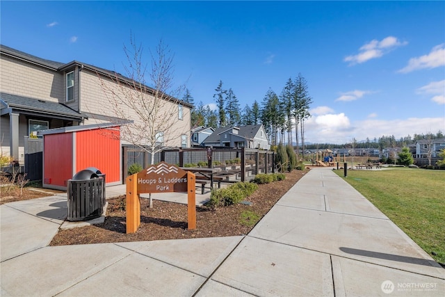 view of community featuring a residential view, a lawn, and fence