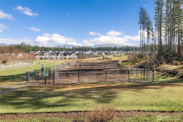 view of yard with a residential view, a gate, fence, and a mountain view