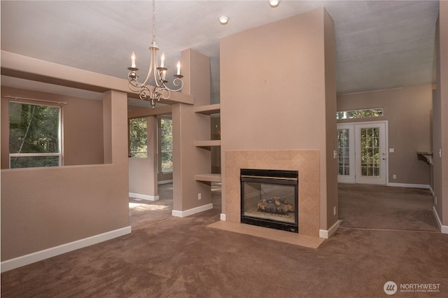 unfurnished living room with an inviting chandelier, carpet flooring, baseboards, and a tile fireplace