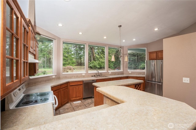 kitchen with a sink, appliances with stainless steel finishes, light countertops, and a healthy amount of sunlight