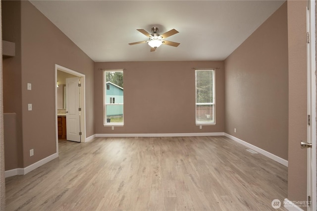 spare room featuring a ceiling fan, baseboards, and light wood-type flooring