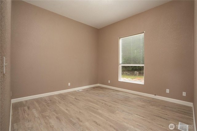 spare room with light wood-type flooring and baseboards