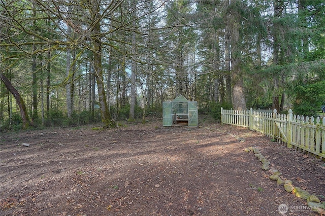 view of yard featuring an exterior structure, an outdoor structure, and fence