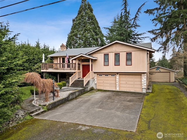 raised ranch featuring a garage, stone siding, driveway, and a chimney