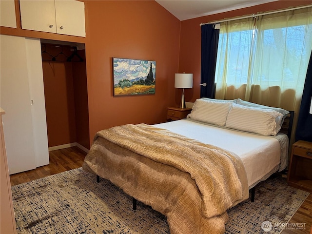 bedroom with a closet, baseboards, and wood finished floors