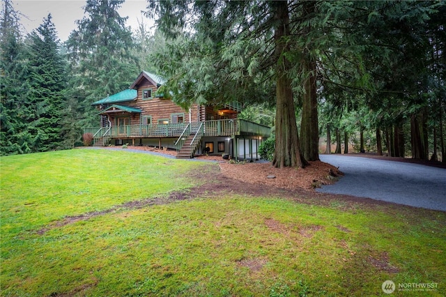 exterior space featuring stairs, a yard, log siding, and a wooden deck