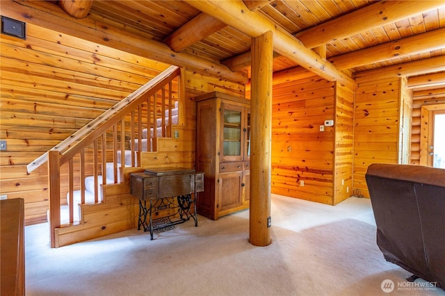 stairs with carpet, wood ceiling, beamed ceiling, and wood walls