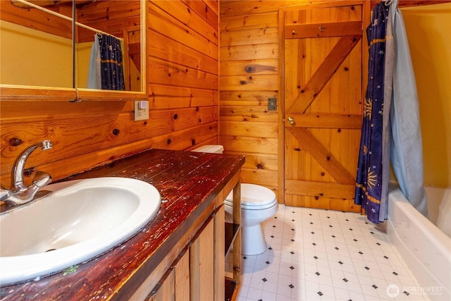 full bathroom featuring vanity, wooden walls, toilet, and tile patterned floors