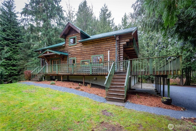 view of front of house featuring a deck, a front yard, log exterior, and stairway