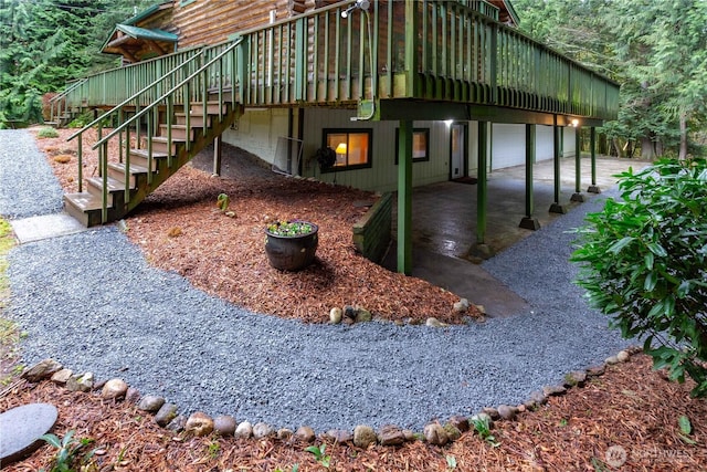 view of property exterior with driveway, stairway, and a wooden deck