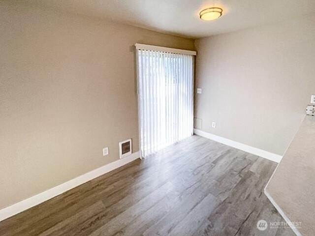 empty room with visible vents, baseboards, and wood finished floors