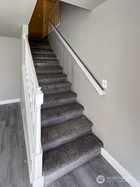 stairs with baseboards and wood finished floors