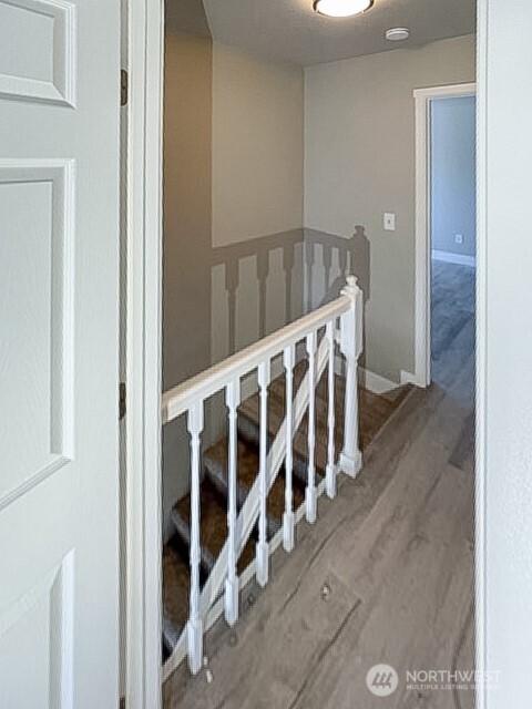 stairway featuring baseboards and wood finished floors