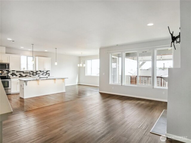 unfurnished living room featuring dark wood finished floors, recessed lighting, and baseboards