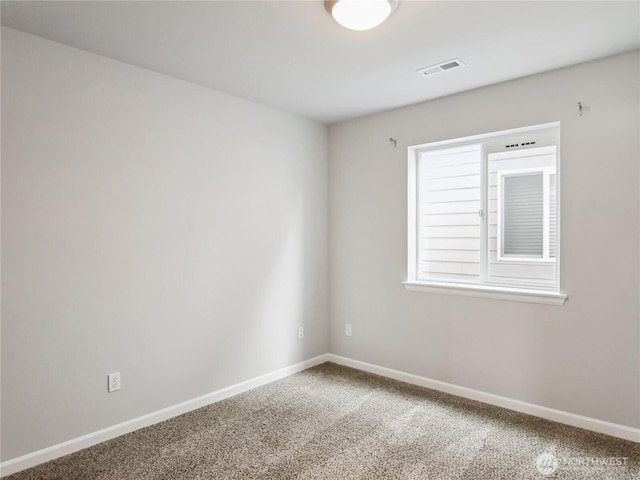 spare room featuring visible vents, baseboards, and carpet