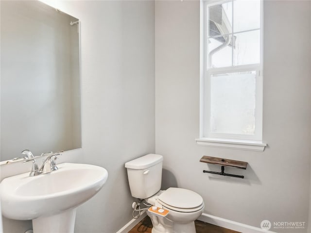 bathroom with toilet, baseboards, and a sink