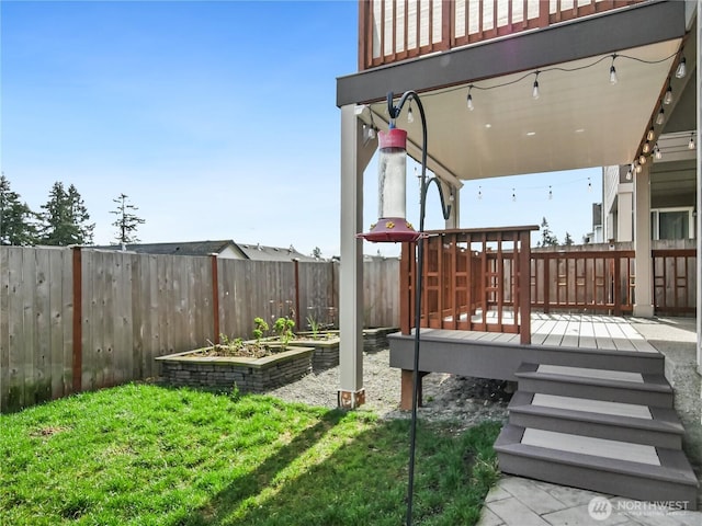 wooden deck with a vegetable garden and fence