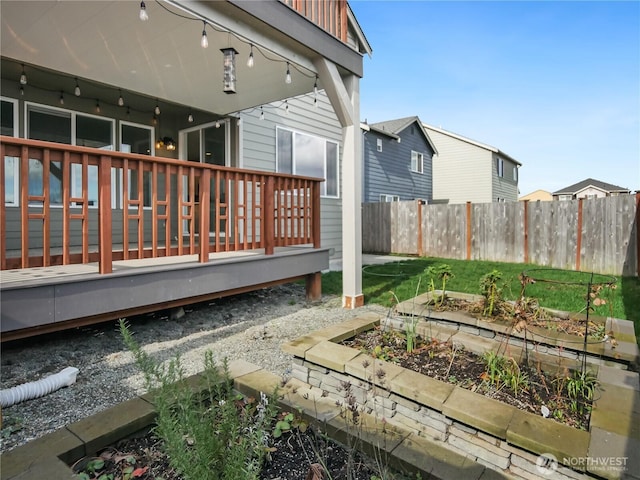 view of yard with a deck, a vegetable garden, and fence