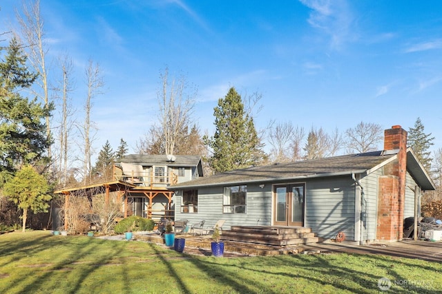 back of house featuring french doors, a lawn, and a chimney