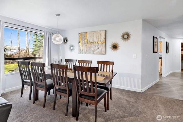 carpeted dining area featuring baseboards