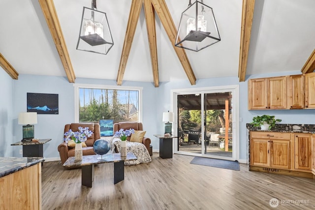 sitting room with vaulted ceiling with beams, light wood-type flooring, and baseboards