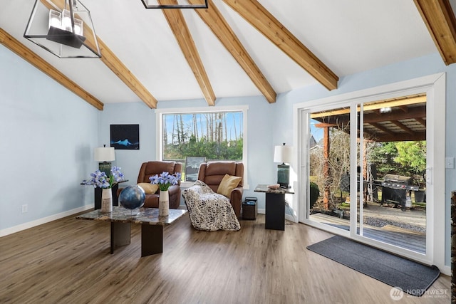 living area with lofted ceiling with beams, baseboards, and wood finished floors