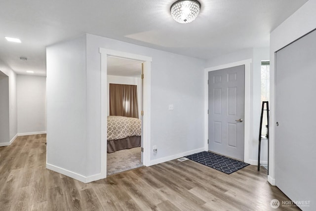 foyer entrance featuring wood finished floors and baseboards