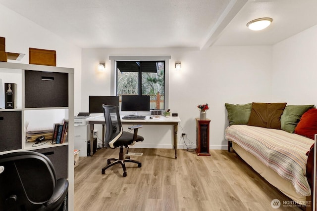 office space with light wood-type flooring, beamed ceiling, and baseboards