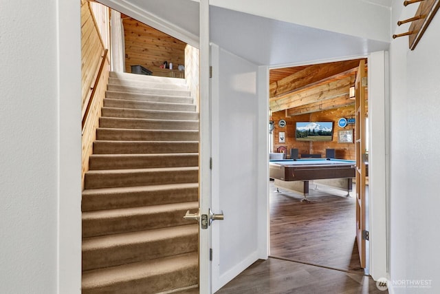 stairway featuring billiards, wooden walls, and wood finished floors