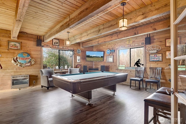 playroom with wood walls, wood finished floors, wood ceiling, heating unit, and beamed ceiling