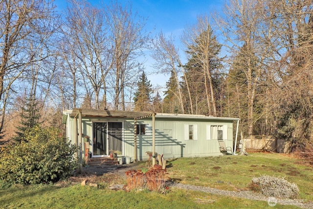 view of front facade with entry steps, a front yard, and fence