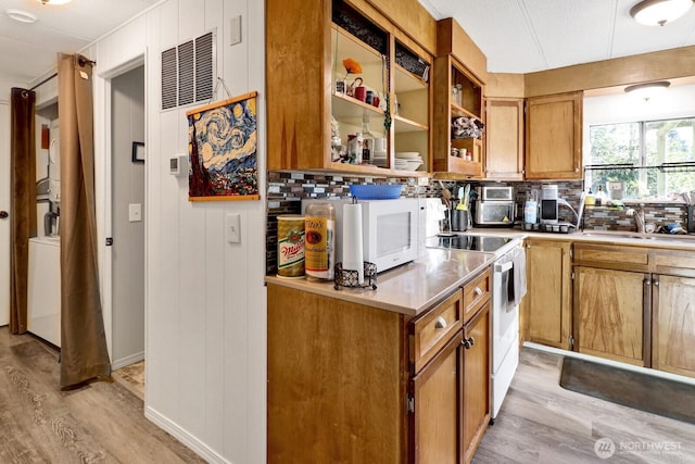 kitchen with light countertops, electric range, brown cabinetry, and light wood-style flooring