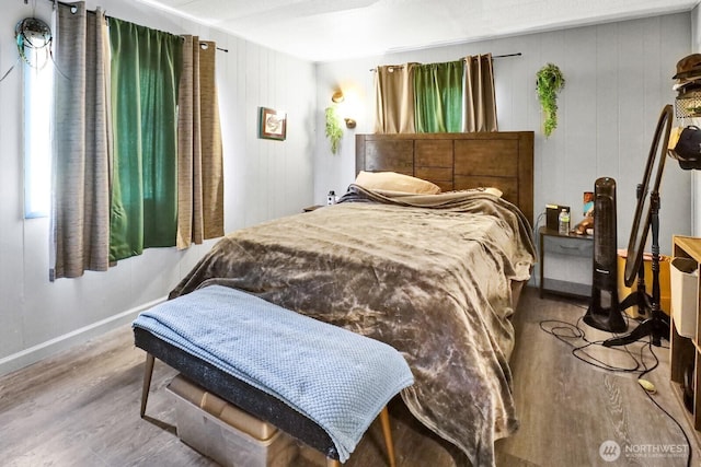 bedroom featuring baseboards and wood finished floors