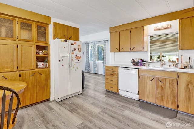 kitchen featuring white appliances, light wood-style flooring, light countertops, and a sink