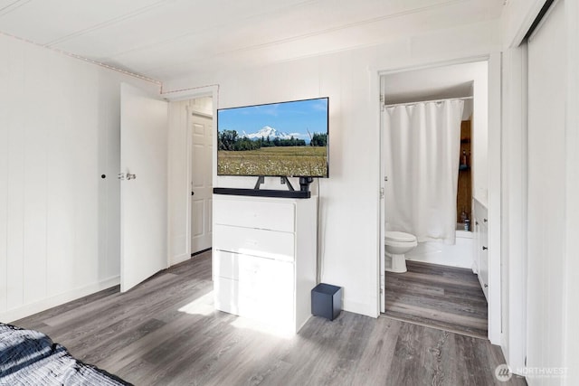 bedroom with ensuite bath and wood finished floors