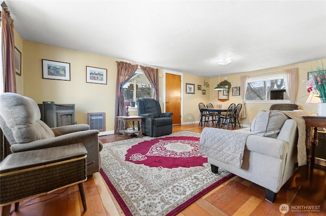 living area featuring heating unit, baseboards, and wood finished floors