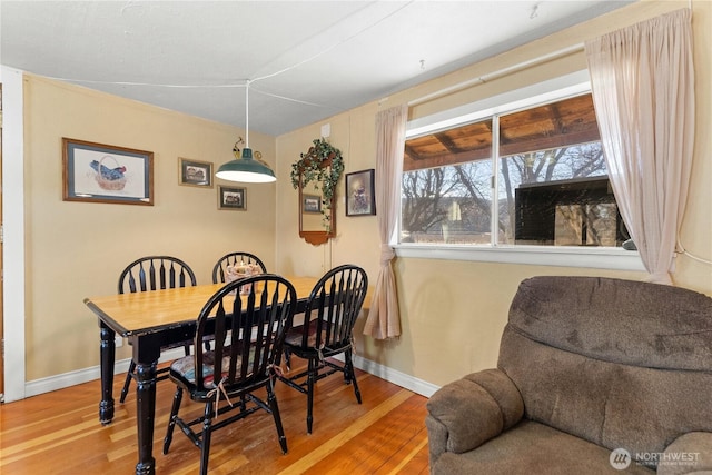 dining space featuring wood finished floors and baseboards