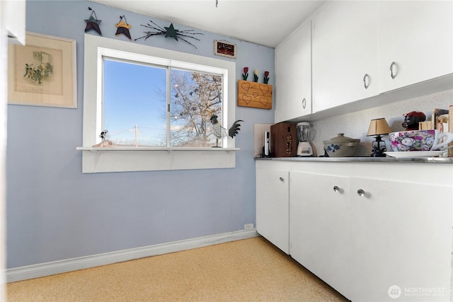 kitchen featuring white cabinets and baseboards