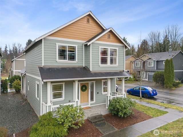 view of front of property with a shingled roof and a porch