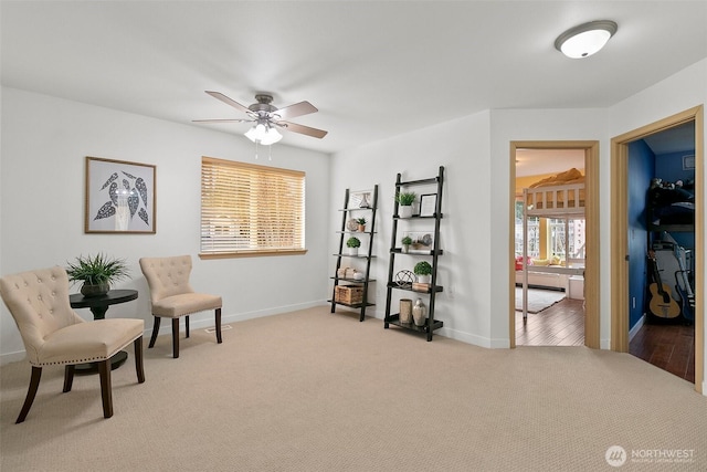 sitting room with a ceiling fan, carpet flooring, and baseboards