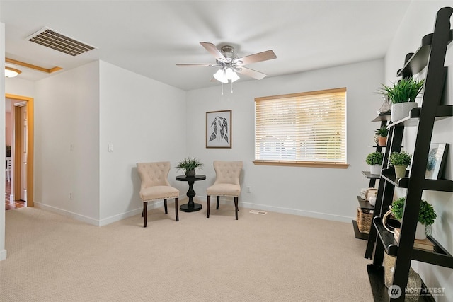 sitting room featuring carpet floors, visible vents, baseboards, and a ceiling fan